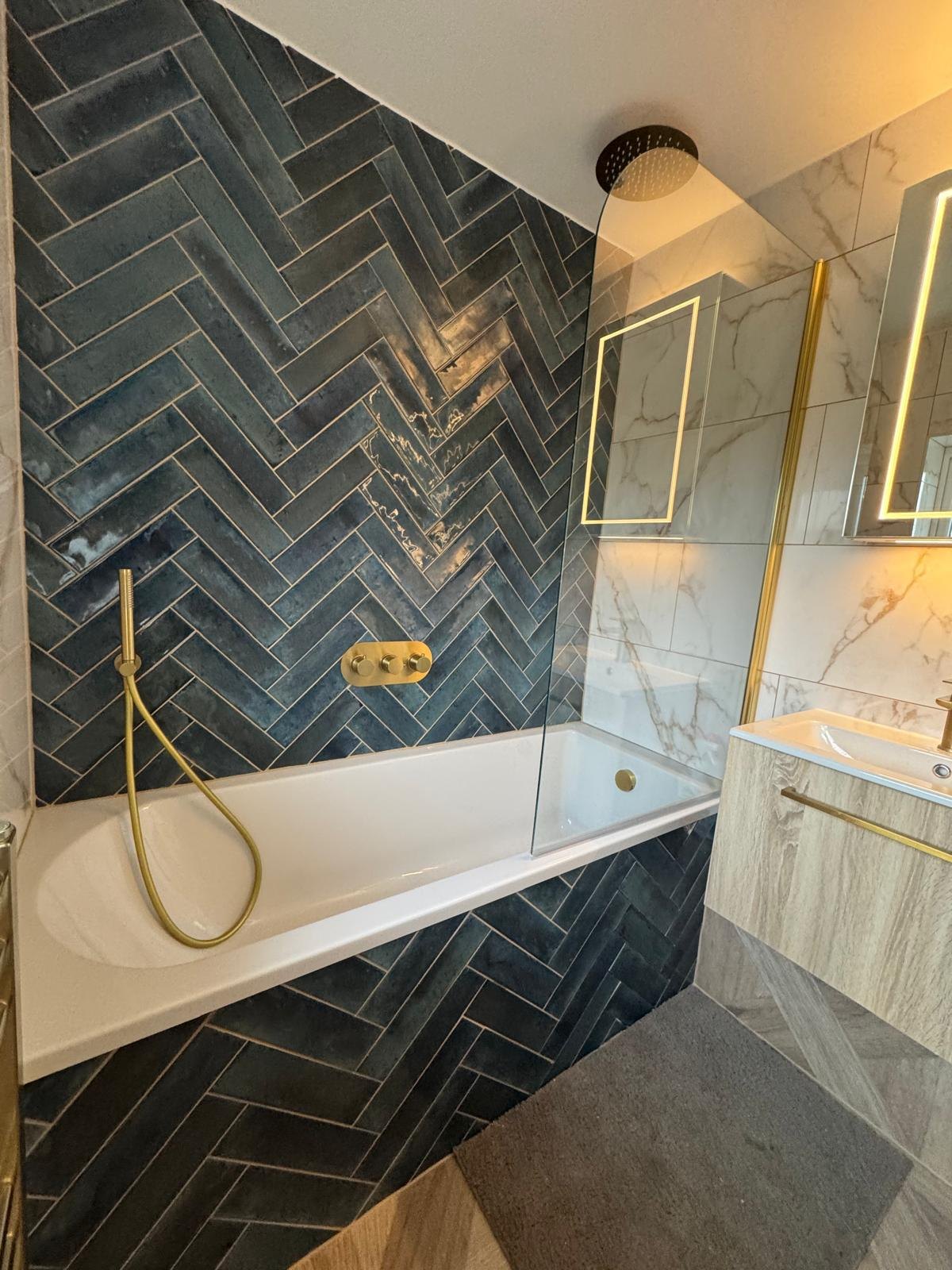 A teal-tiled en-suite with a backlit mirror by Professional Polish Builders in Croydon & South London